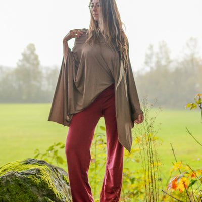 woman wearing a Mocha Tulu Poncho by a field 
